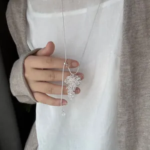 Close-up of a long adjustable sweater chain with a clear crystal grape cluster pendant