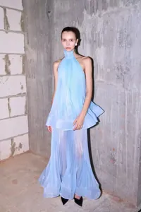 Detaillierte Ansicht eines hellblauen plissierten Neckholder-Tops und Maxirocks am Modell