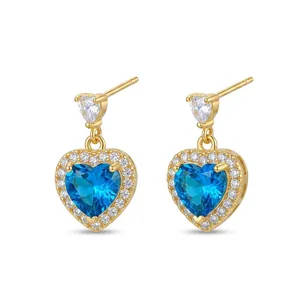 Close-up detail of heart shaped drop earrings featuring blue and clear zircon stones
