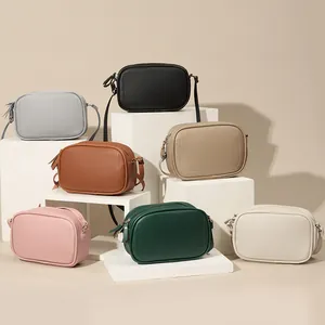 Collection of minimalist PU leather crossbody bags in various colors on white display blocks