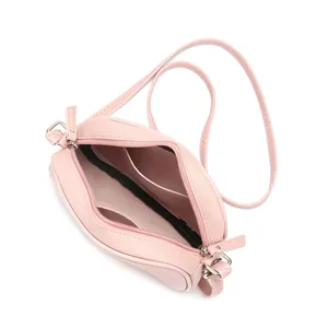 Macro view showing the interior storage compartments of this pink PU leather crossbody bag.