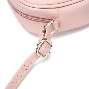 Close-up detail of the adjustable strap and silver buckle on a pink PU leather bag