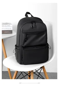 Zaino da lavoro nero minimalista con finitura opaca su una sedia bianca.