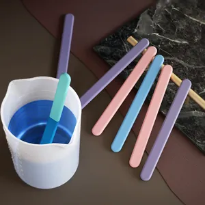Colorful reusable silicone stirring sticks for resin DIY shown with a mixing cup
