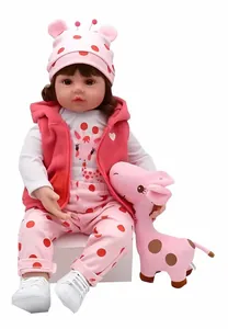 Détail complet d'une poupée reborn de 55 cm en tenue de girafe rose à pois rouges