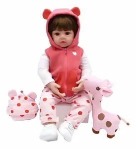 Détail de poupée reborn réaliste de 55 cm en tenue rose à pois avec peluche girafe