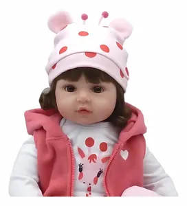 Gros plan d'une poupée Reborn de 55 cm avec des traits réalistes et une tenue rose.