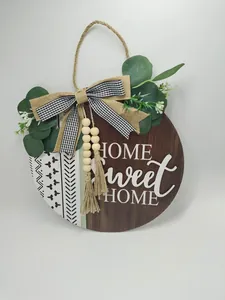Detailed view of rustic Home Sweet Home wooden door sign with eucalyptus and burlap bow