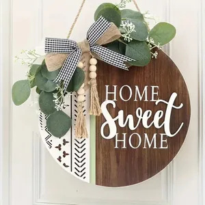 Detailed view of Home Sweet Home wooden door sign with eucalyptus leaves and bow