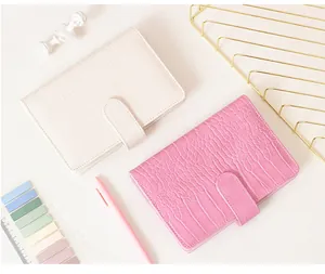 Detailansicht der Macaron-Notizbücher mit Krokodilstruktur in elegantem Rosa und Cremeweiß.