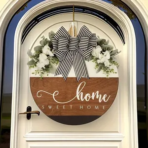 Close-up of a circular wooden door sign featuring Home Sweet Home text and a striped bow