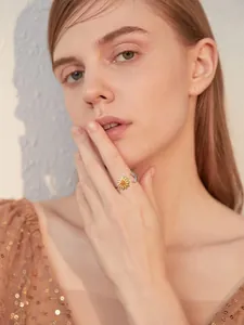 Detailaufnahme eines verstellbaren Rings mit Sonnenblumen- und Monddesign am Finger
