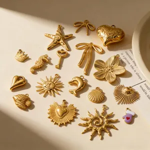 Vista detallada de varios dijes de acero inoxidable chapados en oro de 18K para joyería DIY.