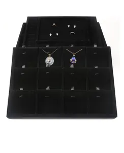Detail view of black velvet jewelry tray with compartments for necklaces and rings