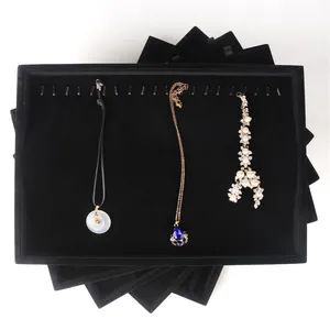 Professional stacked black velvet jewelry trays for elegant necklace and pendant display