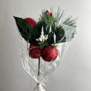 Close-up detail of artificial Christmas pick with red ornament ball, gift box and pine needles