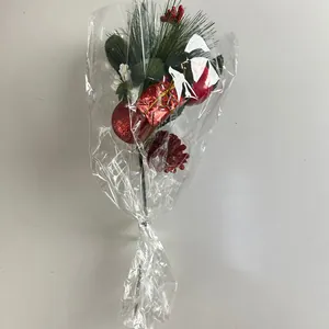 Detailed view of Christmas pick with red bauble, pine needles, and pine cone in wrap
