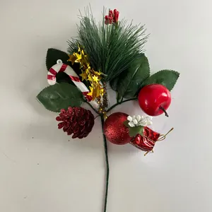 Detailed view of Christmas pick with pine needles, apple, and candy cane decoration.