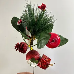 Detailed macro view of a festive Christmas pick featuring pine needles and red ornaments