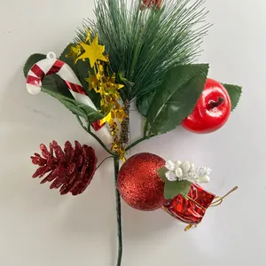 Detail view of a festive Christmas branch with pine needles, apple, and candy cane.