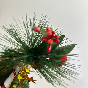 Detailed close-up of artificial Christmas pine needle branch with red berries