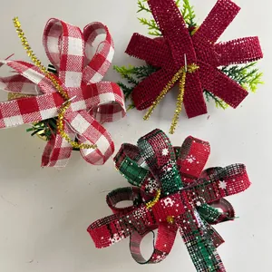 Top view of three assorted Christmas bow ornaments with pine needles and gold tinsel