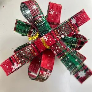 Detailed view of festive red and green plaid Christmas bow with white snowflake prints