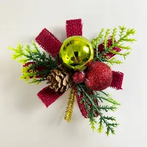 Detail of Christmas ornament with pine needles, pinecone, and festive baubles.