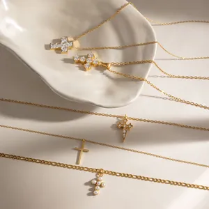 Detail of various 18k gold stainless steel cross pendants with cubic zirconia