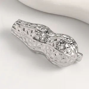 Dettaglio di una spilla creativa a forma di arachide con finitura in argento.