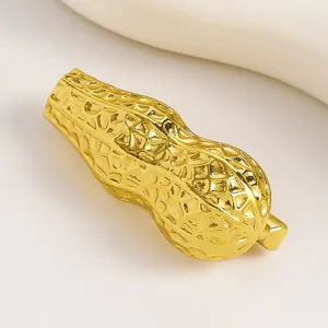 Primo piano di una spilla a forma di arachide dorata con texture realistica