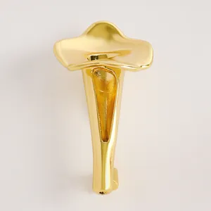 Dettaglio dell'elegante spilla a forma di calla dorata con centro cavo per inserire i fiori
