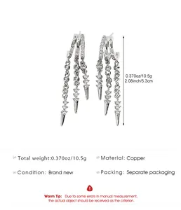 Detailed view of silver tassel hoop earrings with inlaid zircons and rivet pendants.