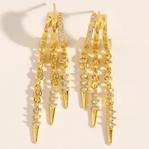 Detailed close-up of fashionable gold tassel earrings featuring zircon studs and spiked ends