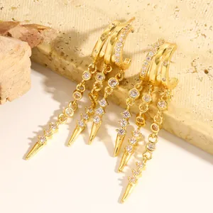 Macro view of luxury gold-plated hoop earrings featuring zircon tassels and spike pendants