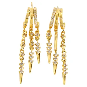 Detailed view of gold multi-layered tassel earrings with zircons and spike drops