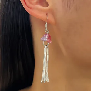 Boucles d'oreilles méduses roses portées, parfaites pour un look de vacances à l'océan