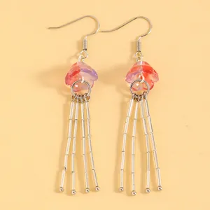 Vue détaillée de boucles d'oreilles méduse dégradé rose et violet à pompons perles