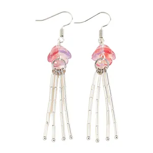 Vue détaillée de boucles d'oreilles méduse roses avec des tentacules argentés pendants
