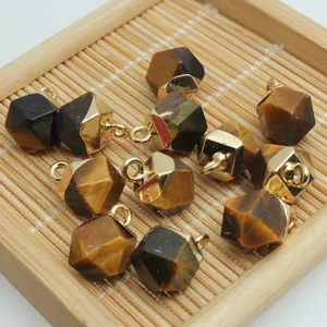 Close-up view of faceted natural tiger eye stone charms with gold-plated caps for DIY jewelry