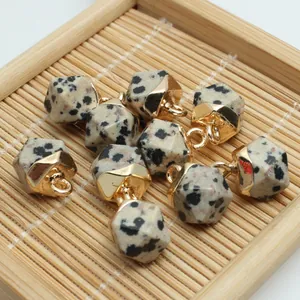 Detailed macro view of faceted Dalmatian jasper stone pendants with gold plated caps
