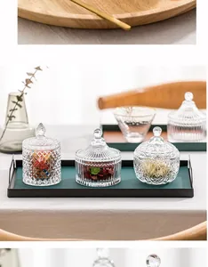 Detailansicht von drei strukturierten Glas-Bonbongläsern mit dekorativen Deckeln.