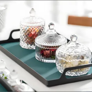 Elegantes Set aus 3 Kristallglas-Bonbongläsern mit Deckel auf einem grünen Tablett