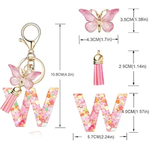 Detail view of pink letter W resin keychain with butterfly charm and heart sequins