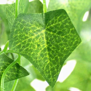 Primo piano di una foglia di edera artificiale verde per decorazione di piante sospese.