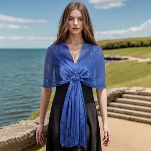 Elegant shimmery blue shawl with buckle detail and fringe shown on a model in sunlight