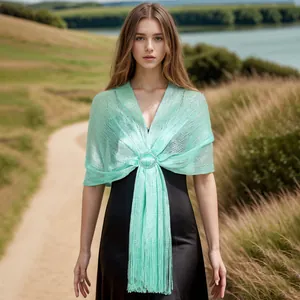Detail of mint green metallic hollow-out shawl with long fringe and decorative buckle.