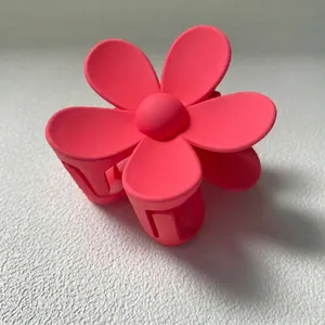 Vue détaillée de l'élégante pince à cheveux fleur rose mat montrant sa texture lisse