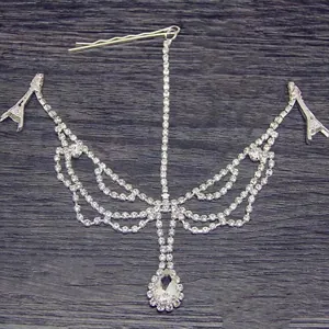 Detailansicht einer silbernen Strass-Haarkette mit einem birnenförmigen Kristallanhänger.