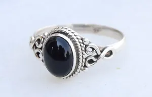 Detailed close-up of a vintage silver alloy ring featuring a large oval black onyx stone